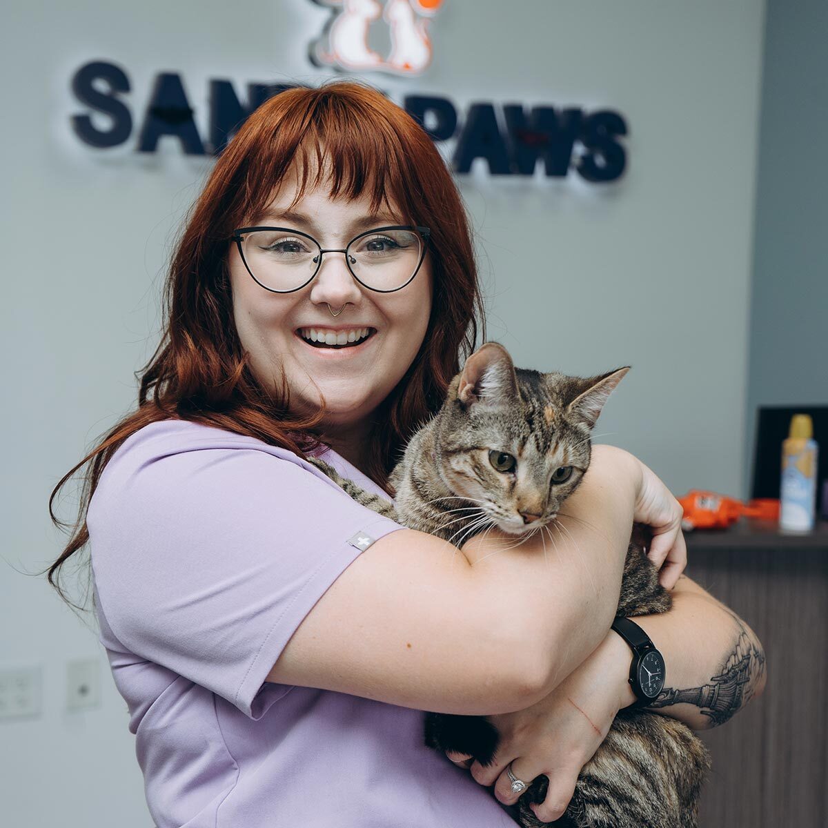 Happy Staff Member Holding Brown Striped Kitten Close